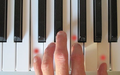 picture of hand playing a chord on piano